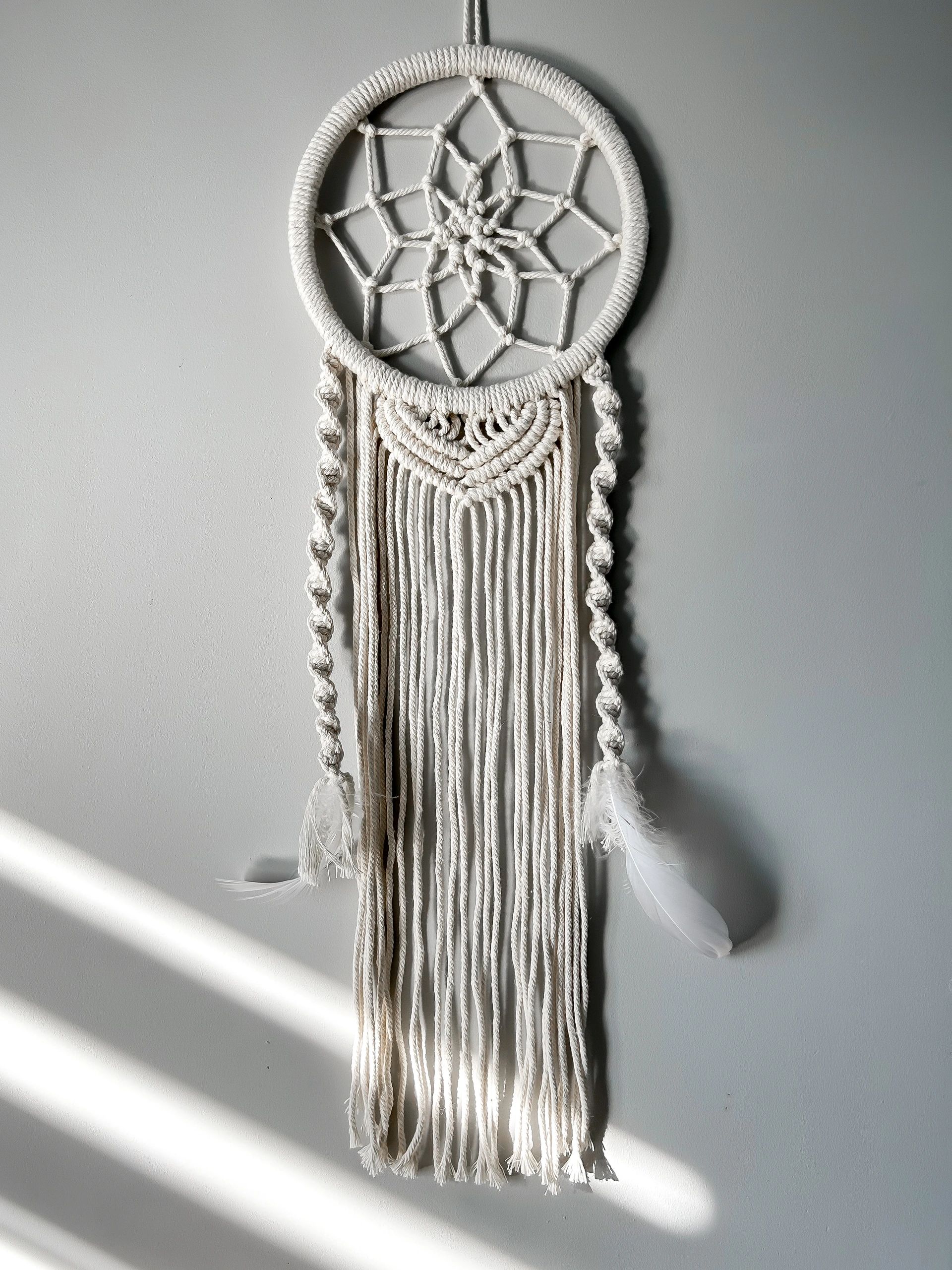 Handmade cotton macrame Dreamcatcher on a gray wall